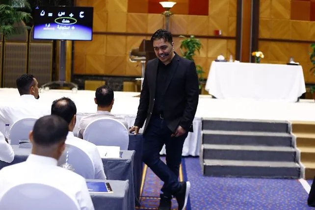 المدرّب يمشي بين المتدربين مبتسمًا