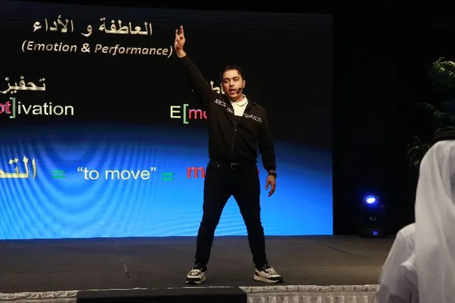 المدرّب يرفع يده أمام شاشة العاطفة والأداء